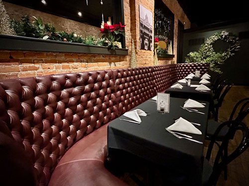 Historic brick wall, bench seating, and dining tables
